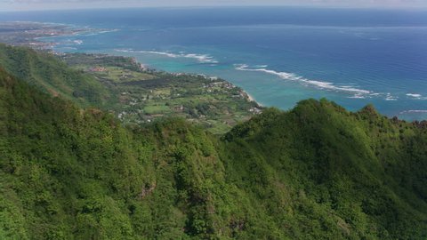 Oahu, Hawaii circa-2018. Aerial view of coastline from forest cliffs. Shot with Cineflex and RED Epic-W Helium.