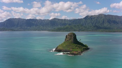 Oahu, Hawaii circa-2018. Aerial view of Mokolii Islet also known as Chinaman's Hat. Shot with Cineflex and RED Epic-W Helium.