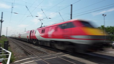 Cambridgeshire, UK - May 23, 2018: A Virgin Trains class 91 electric locomotive passenger train heading north at speed on the East Coast mainline through the flat Cambridgeshire fens in England.