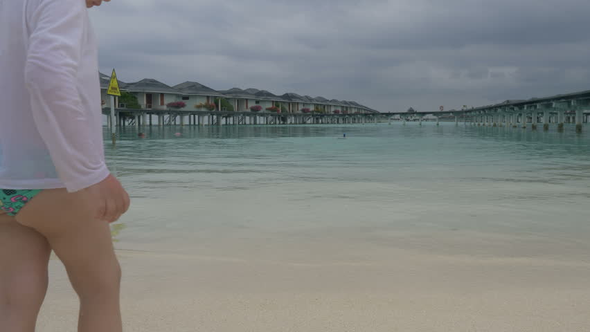 Little girl on the tropical beach resort. Maldives