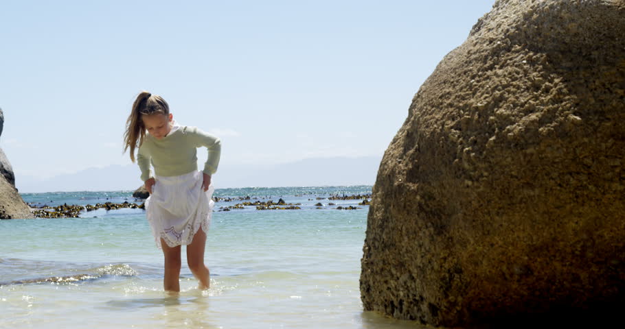 Girl walking on water in the beach on a sunny day 4k