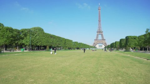 Defocused view of large flat grassy Field of Mars in Paris France. Wide shot of famous French landmark the Eiffel Tower