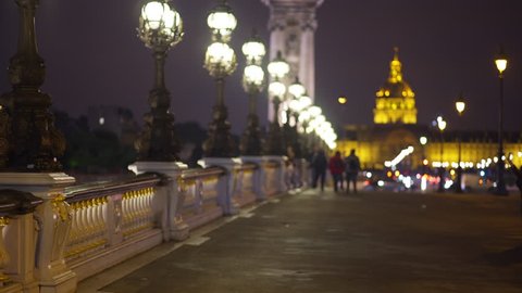 Scenic view of Pont Alexandre III at night with lights and Les Invalides in the distance. Background plate of famous French bridge with historic landmark across in Paris
