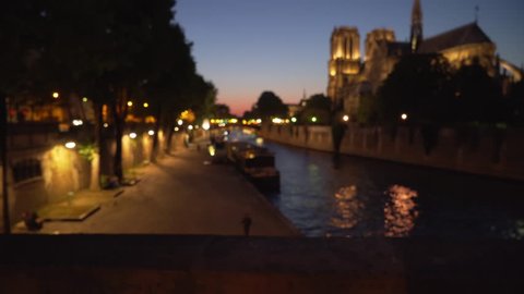 Lovely view of Notre Dame Cathedral across the River Seine in Paris. Night scene of historic French landmark near body of water in France