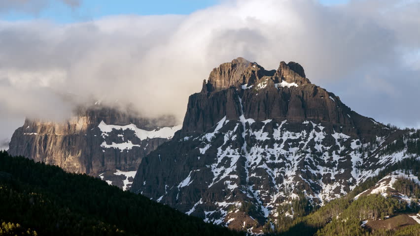 Time lapse of Amphitheater Mountain as clouds roll over top as the sun starts to set in Yellowstone.