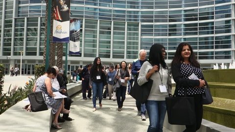 Anaheim, CA / USA - May 30, 2018: Attendees of a medical conference walk out of a meeting at the Anaheim Convention Center on a sunny day