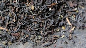 Rotating loose black darjeeling tea leaves on wooden board