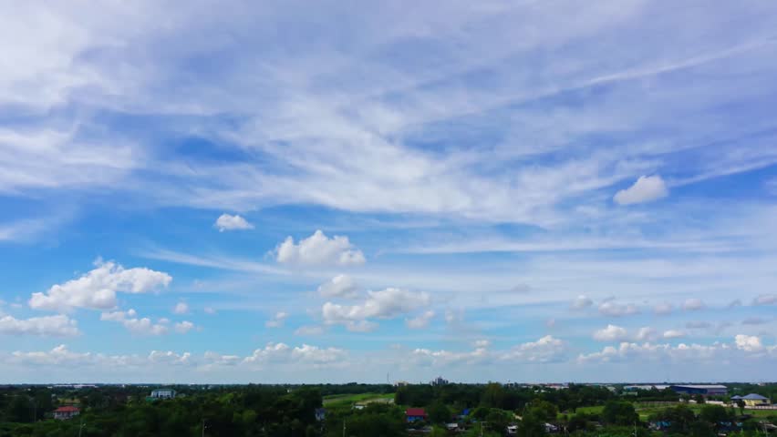Time lapse of city landscapes with white clouds over blue sky.