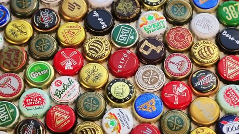 Moscow, Russia-30, 2018: beer bottle caps background, mix of different world brands: grolsch, Bud, Bavaria, Miller, Heineken, Baltika; Corona Extra, etc. Rotation video