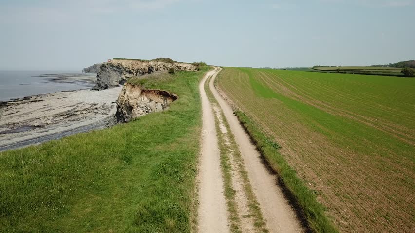 Aerial of Rocky Jurrasic beach near Kilve Somerset England with many fossils flying over the cliffs