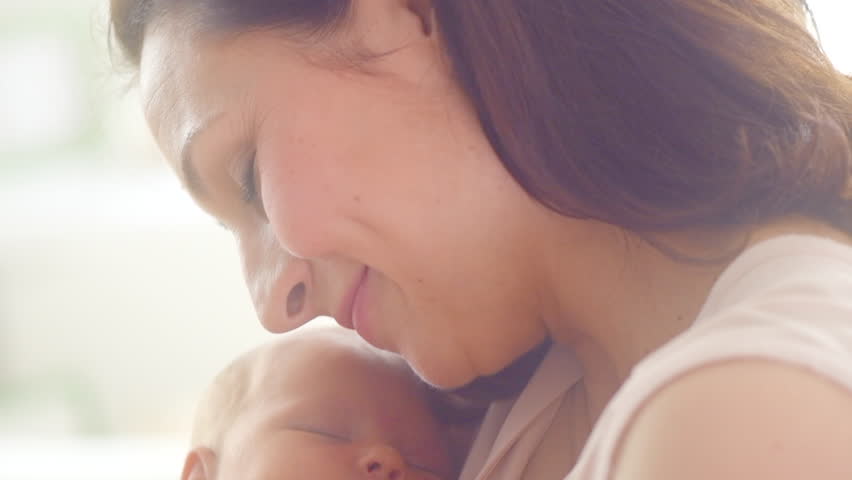 Mother and her Newborn Baby. Happy Mother holding her New born Baby girl kissing and hugging. Maternity concept. Parenthood. Motherhood. Beautiful Happy Family. Adoption. Slow motion 4K UHD 3840X2160 | Shutterstock HD Video #1011804623