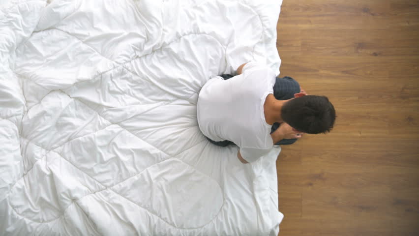 The depressed man sitting on the bed. view from above Royalty-Free Stock Footage #1011808421