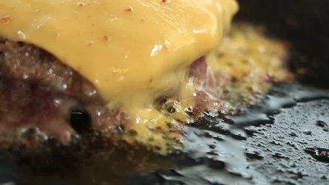 Close up of Grilled beef for hamburger Grilled on the pan And put the cheese on top.