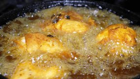 Deep frying chicken in a pan.