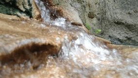 SLOW MOTION : Blurry waterfall on rocks closeup background
