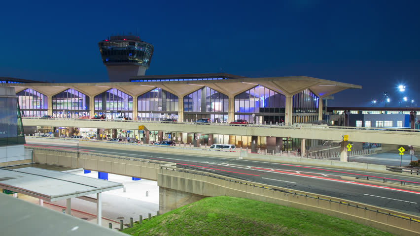 Airport Tower in Newark NJ with Terminal Exterior Traffic Timelapse with Colorful Streaking Lights from Cars outside Arrivals and Departures Architecture at Night