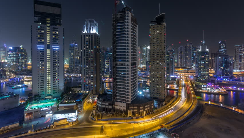 Water canal and promenade on Dubai Marina skyline at night timelapse. Residential towers with lighting and illumination. Floating yachts and boats with traffic near skyscrapers | Shutterstock HD Video #1011839696