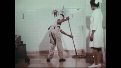 1970s: Janitor mops hospital nursery floor. Nurse talks to janitor. Doctors perform blood transfusion. Babies in hospital cribs.