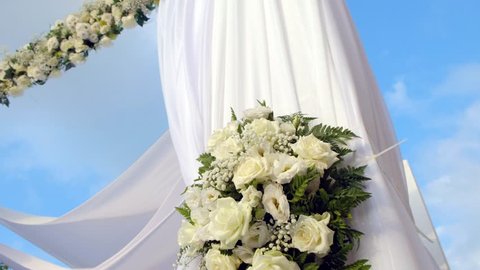 Beautiful video 4k of the Jewish Hupa with conducting of the camera from top to down, wedding putdoor .Beautifully registered Huppa with a set of flowers.Closeup on a bouquet from roses.