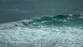Panning clip of the big wave covered surfersman. Uluwatu Beach, Bali, Indonesia - January 2018
