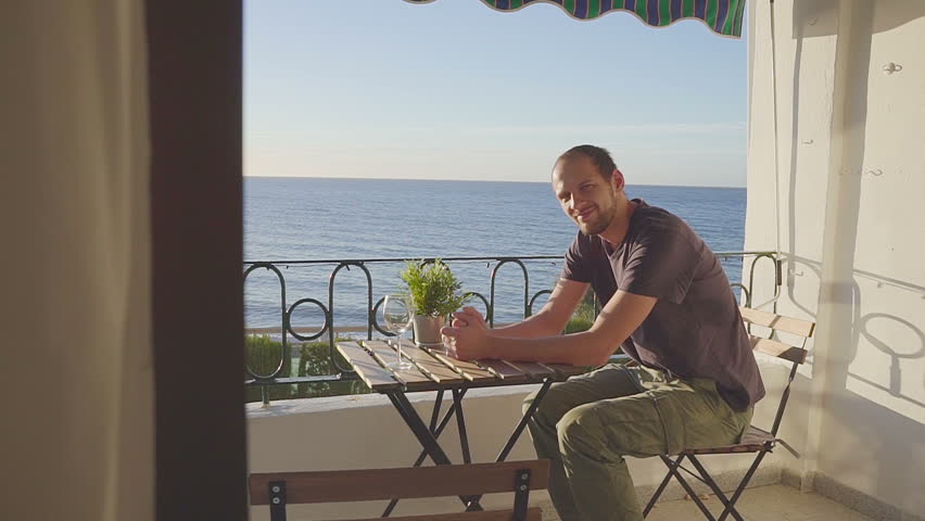 Happy young man relaxing on luxury hotel terrace