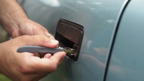 Male Mechanic Holding Lockpicker To Open  Car Door