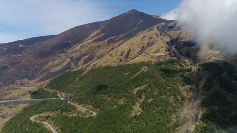 Aerial footage of Mount Etna emerging from clouds Etna an active stratovolcano on east coast of Sicily Italy in the Metropolitan City of Catania and is the highest active volcano in Europe 4k quality