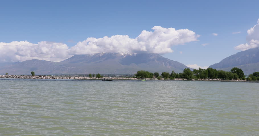Young girl on bow of boat mountain lake. Front of boat Point of view, POV across mountain valley lake. Young girl enjoys the summer recreation and activity. Family fun.