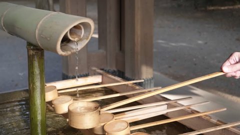 slow motion shot of a bamboo water dipper filling at meiji jingu shrine in tokyo, japan- originally recorded at 180p 库存视频