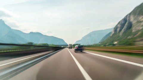 Time Lapse Driver POV motion blur forward driving in Italy countryside road in Dolomite area highway through mountains and valley nature scenic.