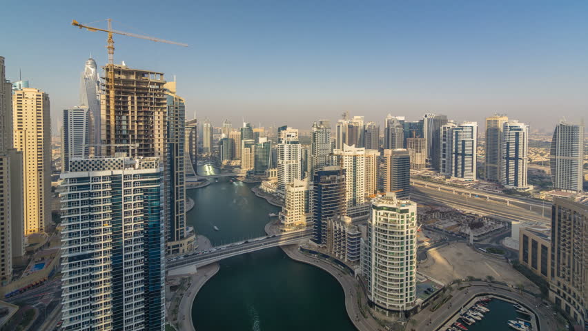 Amazing colorful dubai marina skyline during sunset timelapse. Great perspective of multiple tallest skyscrapers of the world with yachts and boats. Sunlight over buildings. United Arab Emirates.