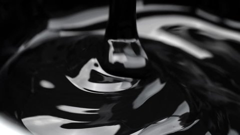 Black viscous liquid flows. Close up.