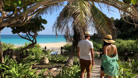 Couple Walking Down to Beach of Tulum Mexico Tracking Shot