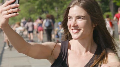 A beautiful young woman taking a selfie with her phone outside, 4K slow motion Stock Video