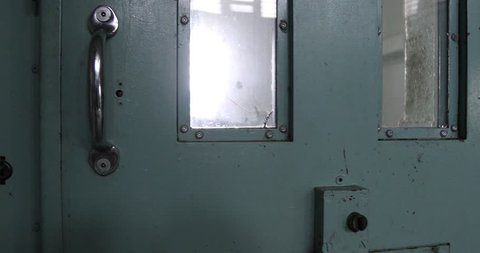 Door closing on solitary confinement cell in old prison.