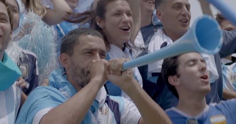 Argentinian football fans jumping and cheering at football match, slow motion