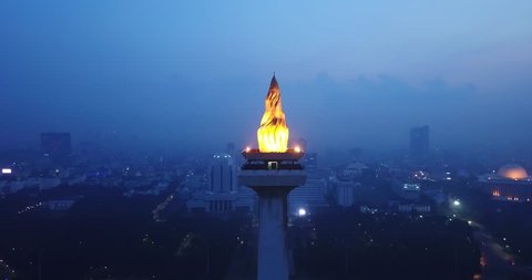 JAKARTA, Indonesia - May 30, 2018: Beautiful aerial scenery of National Monument at night in Central Jakarta, Indonesia. Shot in 4k resolution from a drone flying backwards