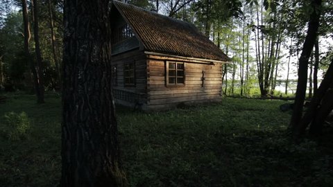 Old wooden house in the woods near the lake Svir at sunrise