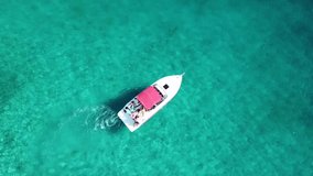 Aerial drone bird's eye view video of speedboat crusing in caribbean tropical emerald and turquoise colour clear waters