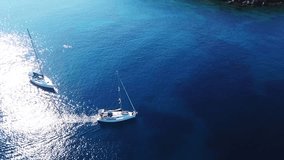 Aerial drone bird's eye view video of luxury yacht cruising in bay below archaeological site of Cape Sounio, Temple of Poseidon, Attica, Greece