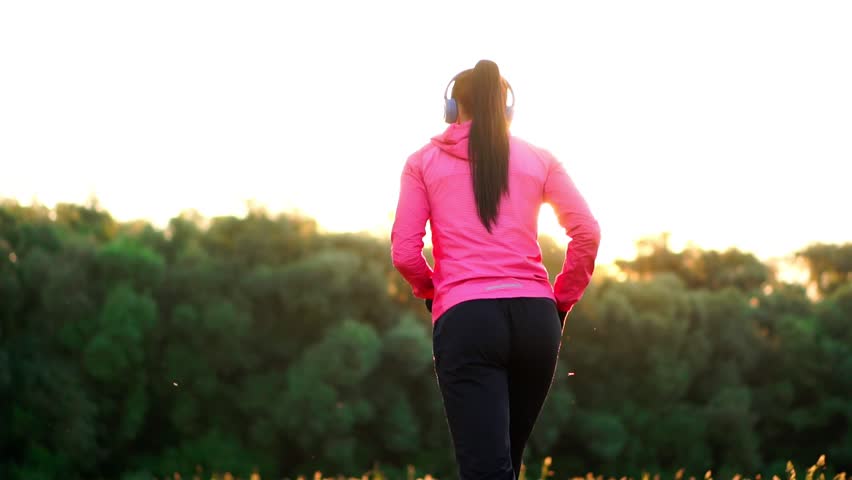 The girl warms up early in the morning before training preparing for a run in the sun | Shutterstock HD Video #1011928910