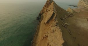 aerial shot over huge cliff on beach blue green water sea weeds 4 calm blue water in Persian Gulf 4k raw footage