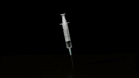 Syringe falling and sticking on black background, Ultra Slow Motion - Powered by Shutterstock - Get 15% off with code: PIKWIZARD15