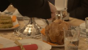 Hands cut fried chicken at the festive Christmas table