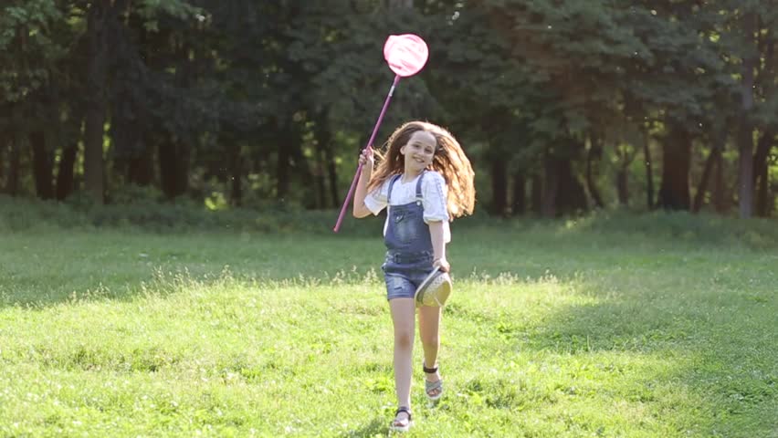 Girl with a net trying to catch butterflies.