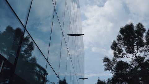 Time lapse. Clouds reflection on a glass building.