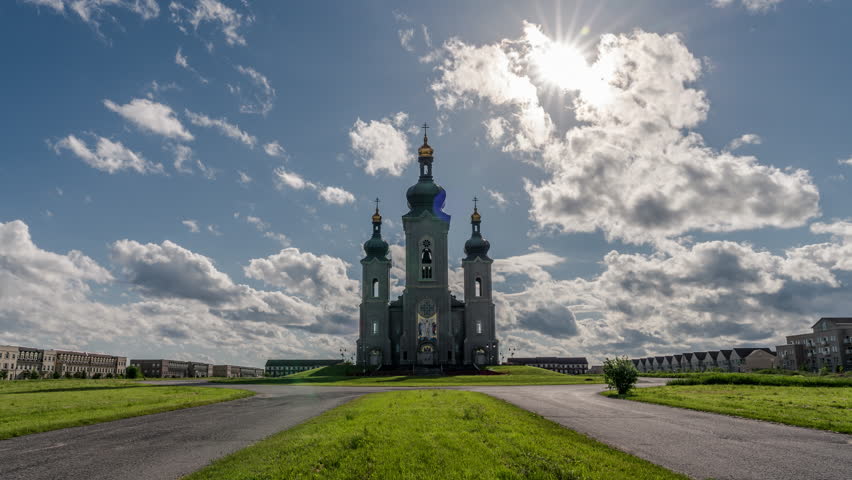 Beautiful historic cathedral church architecture in a field of grass on a summers day. Epic white clouds move across a blue sky. Located in Markham near Toronto, Canada.