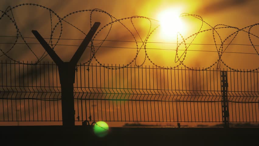 fence prison strict regime the silhouette barbed wire. illegal immigration fence from refugees. lifestyle illegal immigration concept prison prison fence Royalty-Free Stock Footage #1011965798