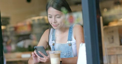 Woman use of smart phone inside coffee shop