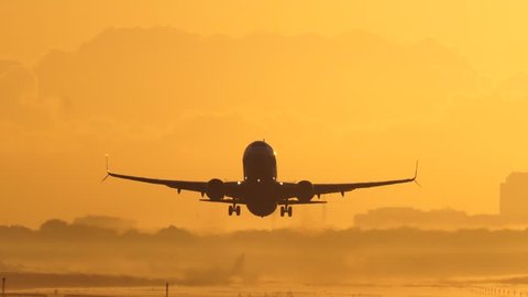 4K passenger airplane take off during sunrise